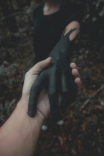 black and white po of someone holding their hand in the woods