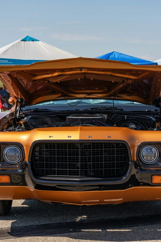 an orange car is parked next to some tents