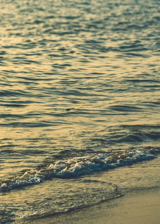 the waves roll in onto the beach next to the shore