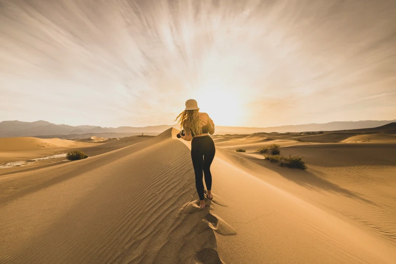 the person is walking down the sand dunes