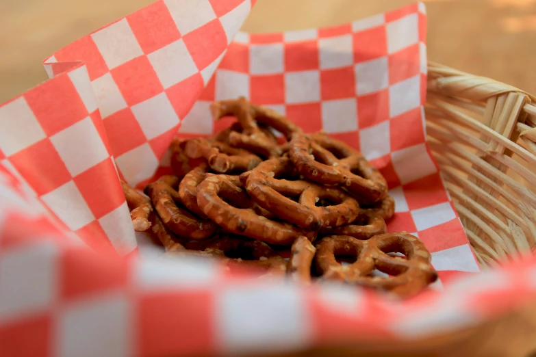 a basket of mini pretzels sitting next to a cup
