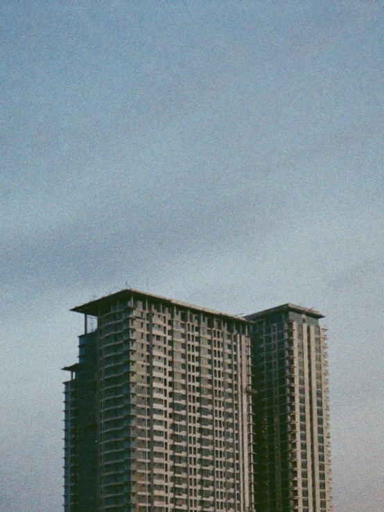 two tall buildings with balconies and a flag flying on them