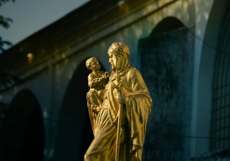 a statue sitting next to a stone archway