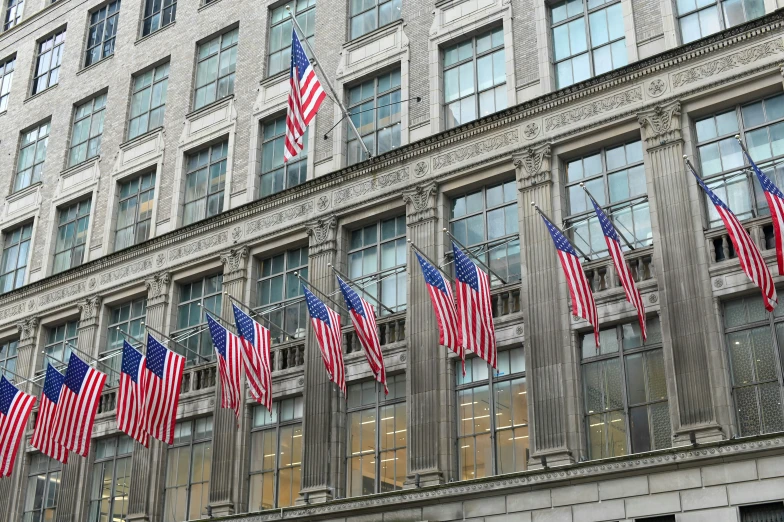 a tall building covered in american flags and windows