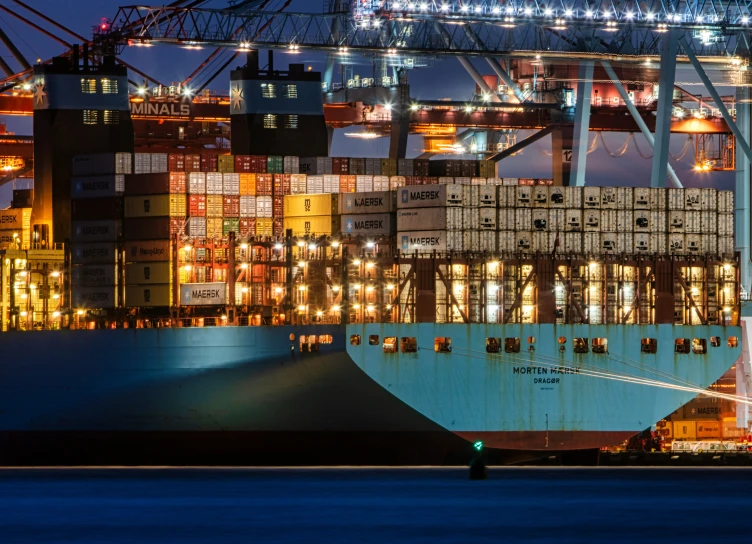 a large ship in a harbor full of containers