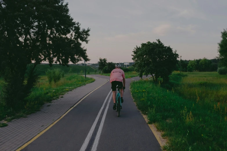 a person riding on a bike down a country road