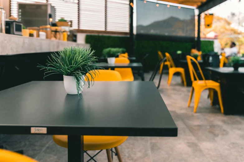 a black table with yellow chairs in front of it