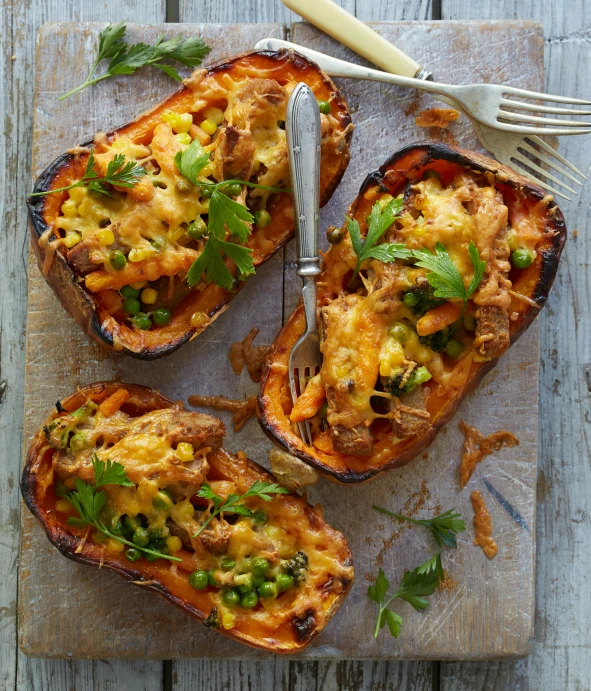 three pieces of food sitting on a  board next to a knife and fork