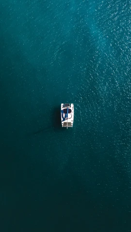 a boat sitting in the middle of an ocean