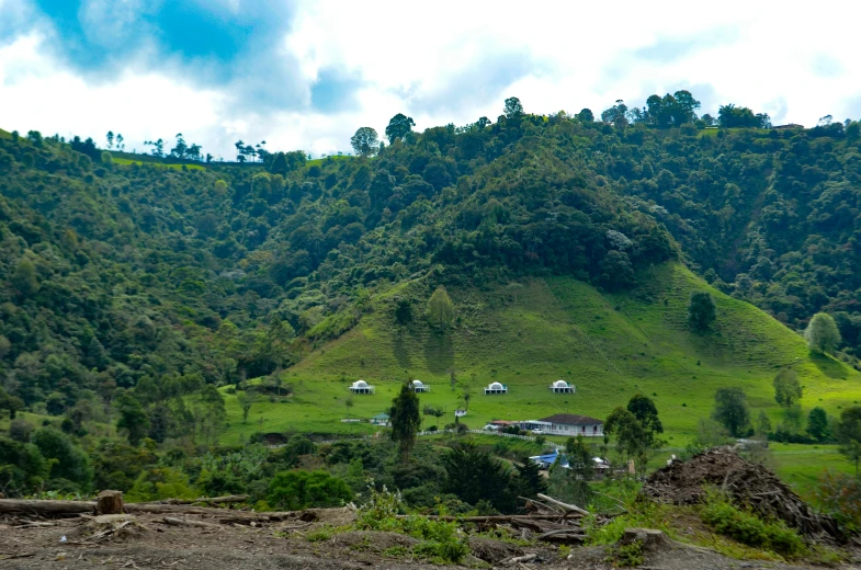 a large mountain with green grass and hills