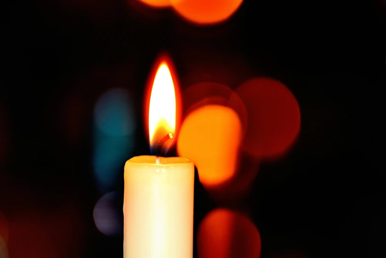 a single candle with blurred background during the day