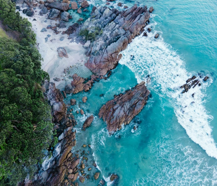 the beach has some rocks along the water