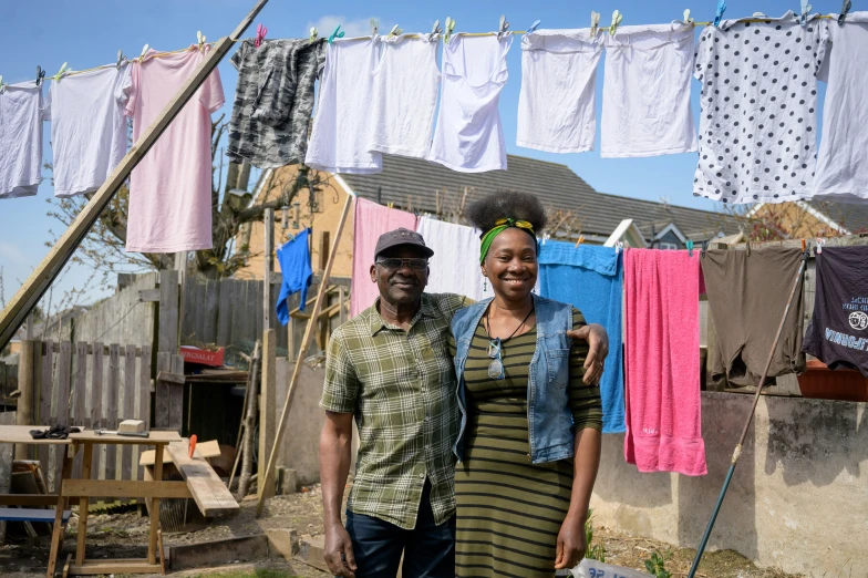 a couple of people standing in front of a bunch of clothes