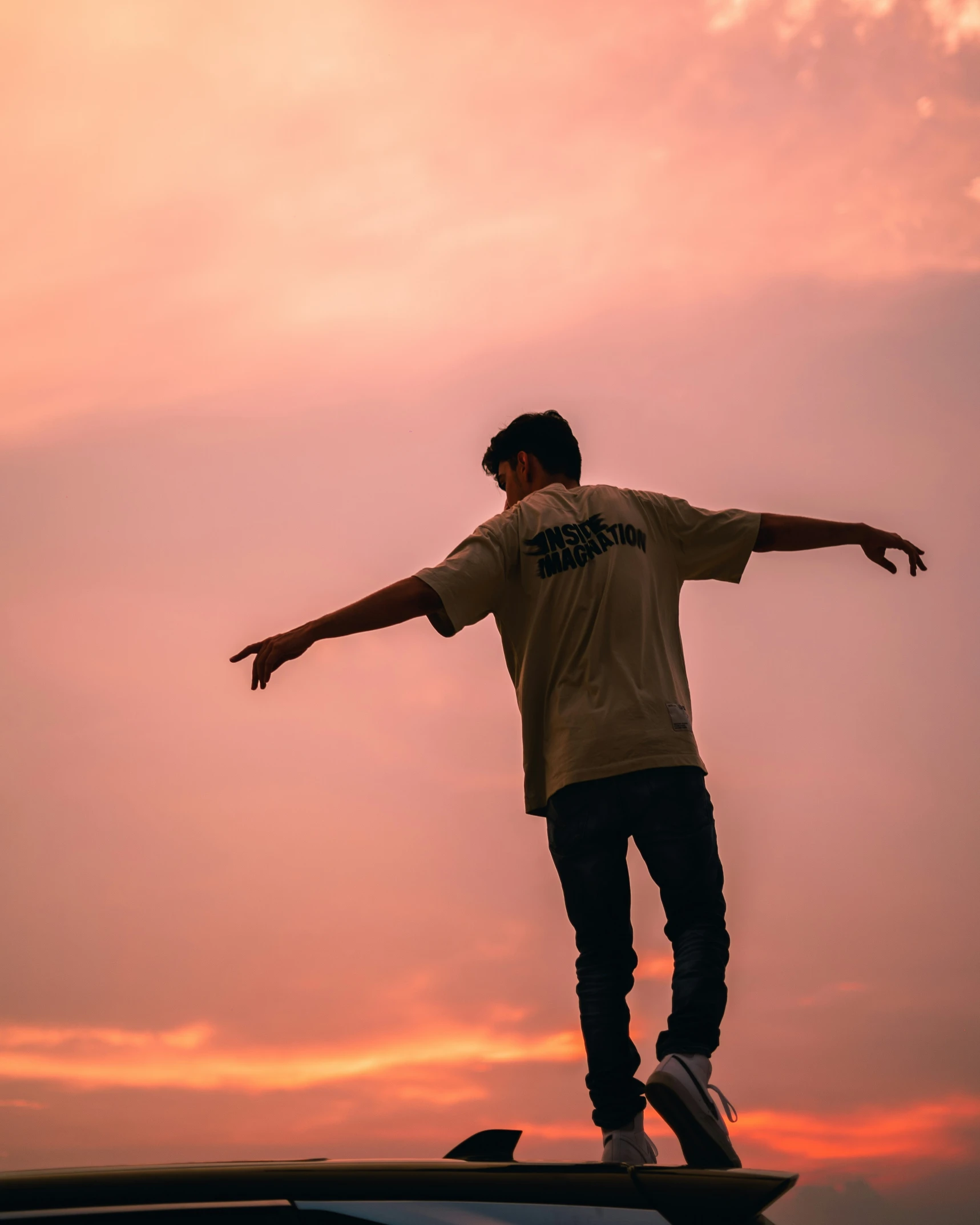 a person riding a skateboard on a ledge at sunset