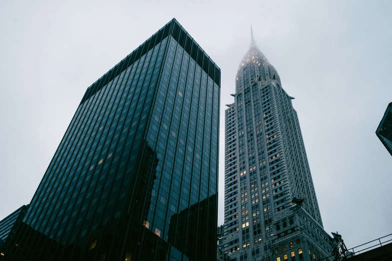 two tall buildings are standing in front of each other