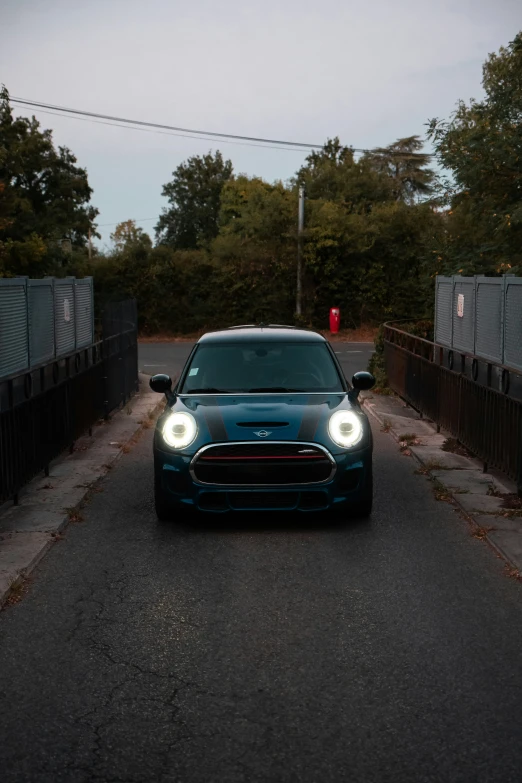 a blue minivan parked on the street in front of some fencing