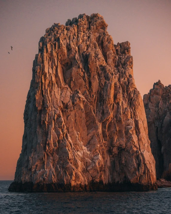 an outcropping in the ocean at sunrise