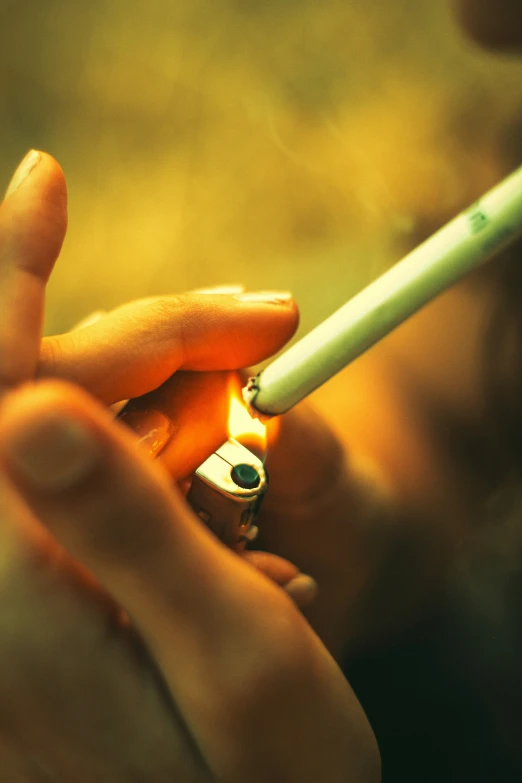 a woman's hands are holding a lighter and an iphone