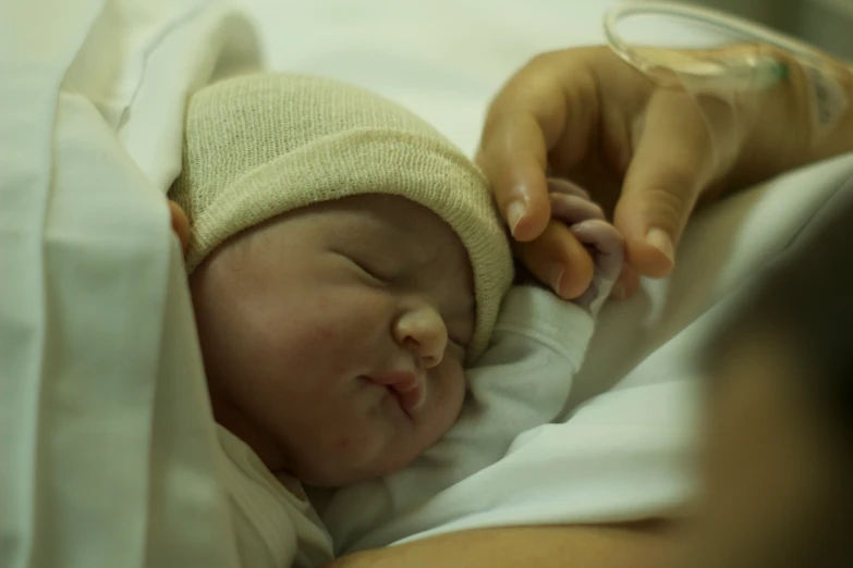 a person is holding a baby who has been swaddled in a blanket