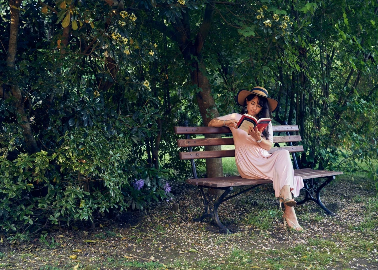 a woman wearing a hat sitting on a bench