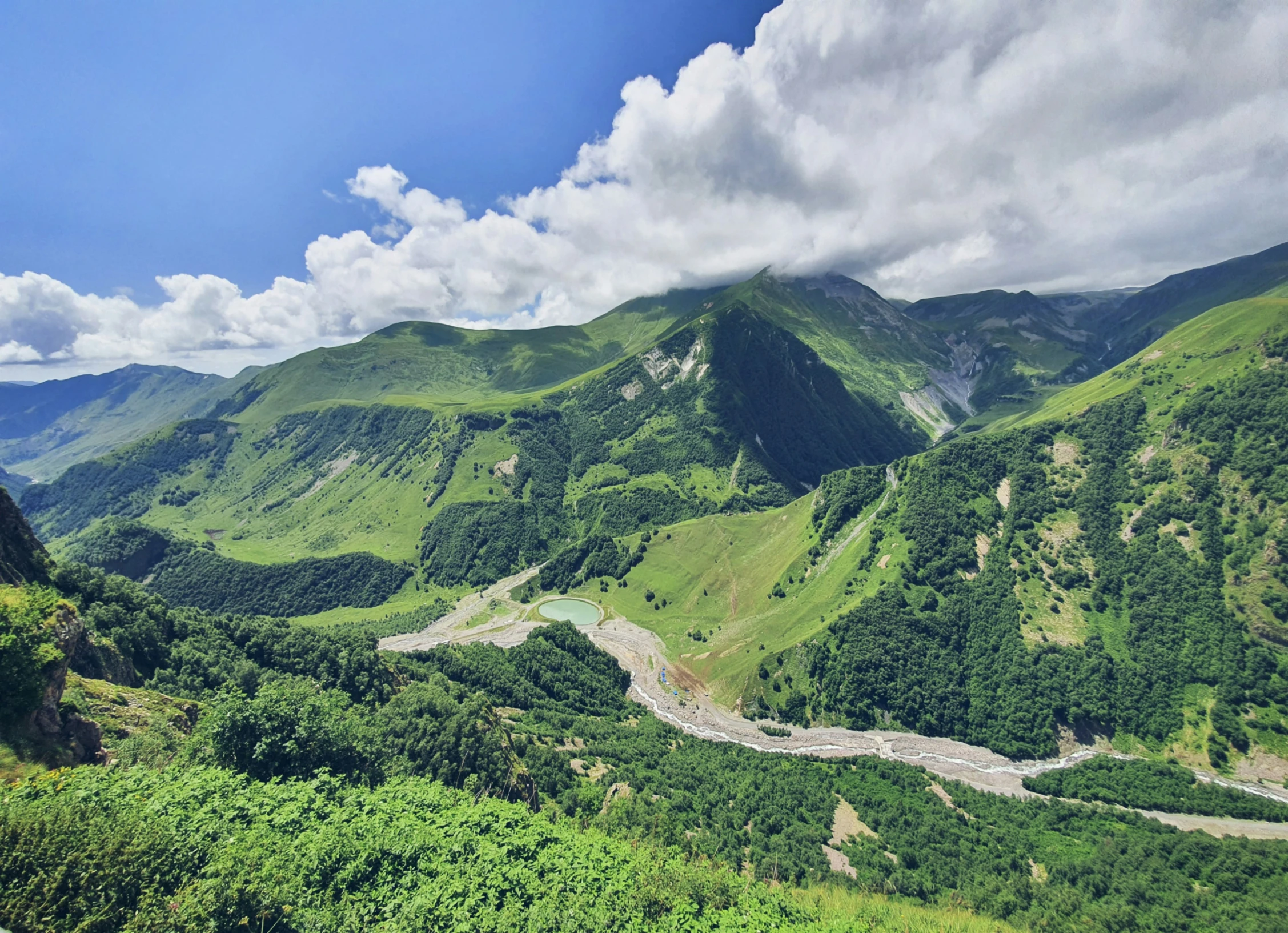 some green mountains on a sunny day with white clouds