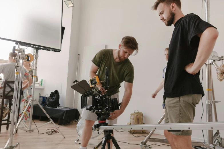 two people are recording soing on a small tripod