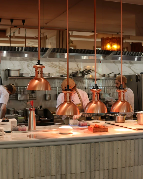 people are in a kitchen preparing food at the restaurant