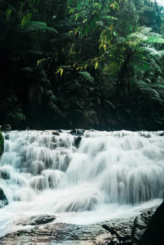 a large waterfall with trees surrounding it