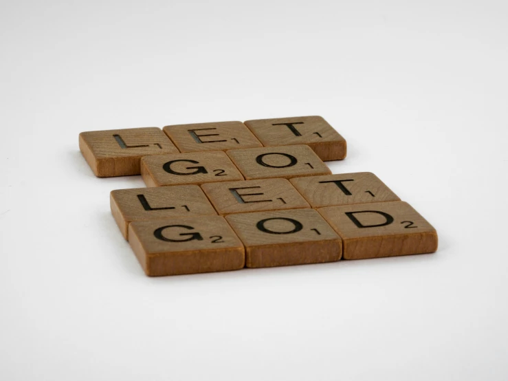 three pieces of wooden text tiles spelling let it go and get it good