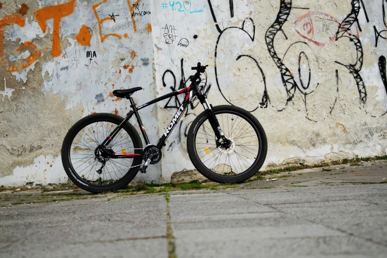 a bicycle leaned against a wall covered in graffiti