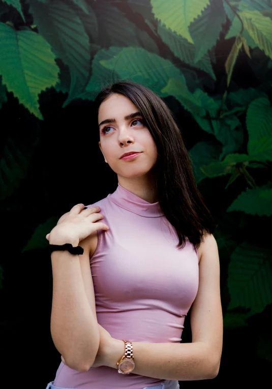 the woman poses in front of green wall