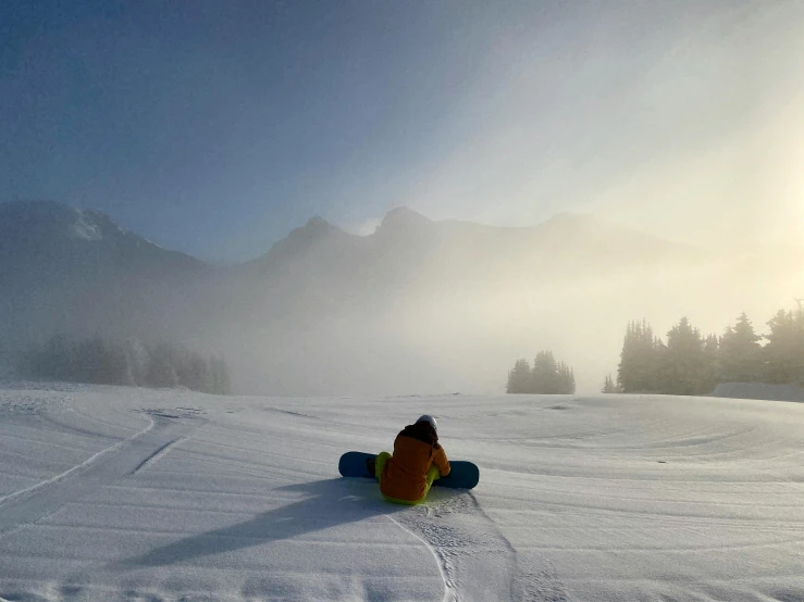 a person riding a snowboard down a snow covered slope