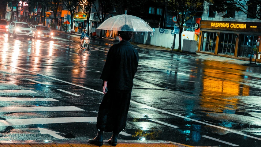 a man with an umbrella standing in the middle of the street