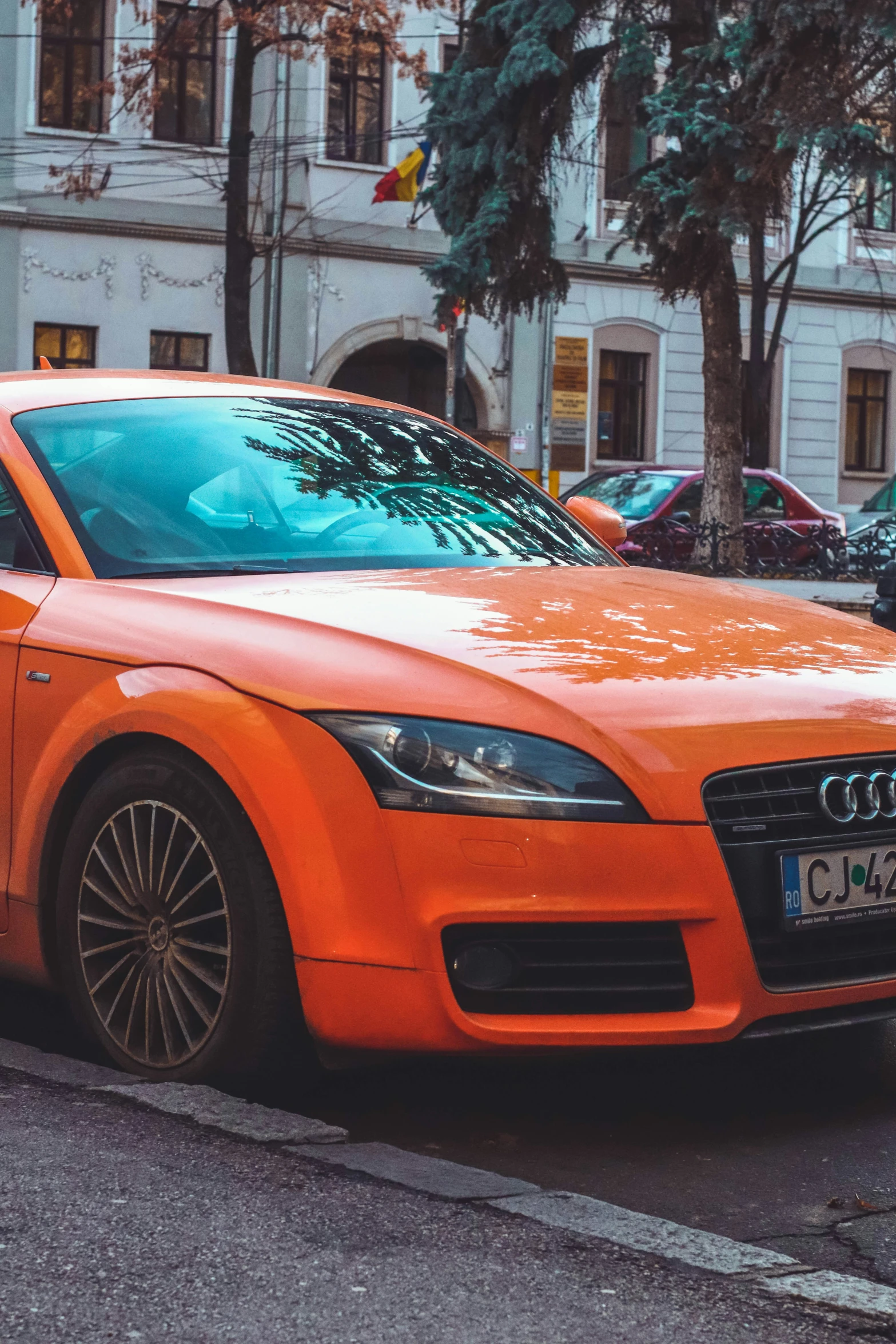 an orange sports car parked near a traffic signal