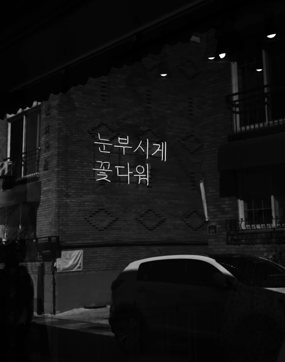 a car parked on the side of a brick building in front of a window