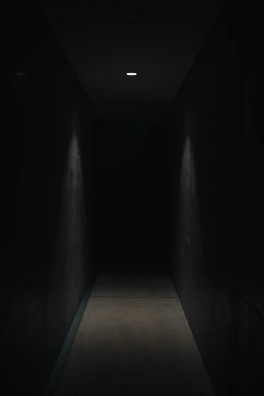 empty hallway between two walls with dim lighting