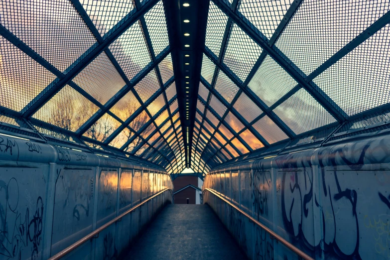 an indoor walkway that is covered with graffiti