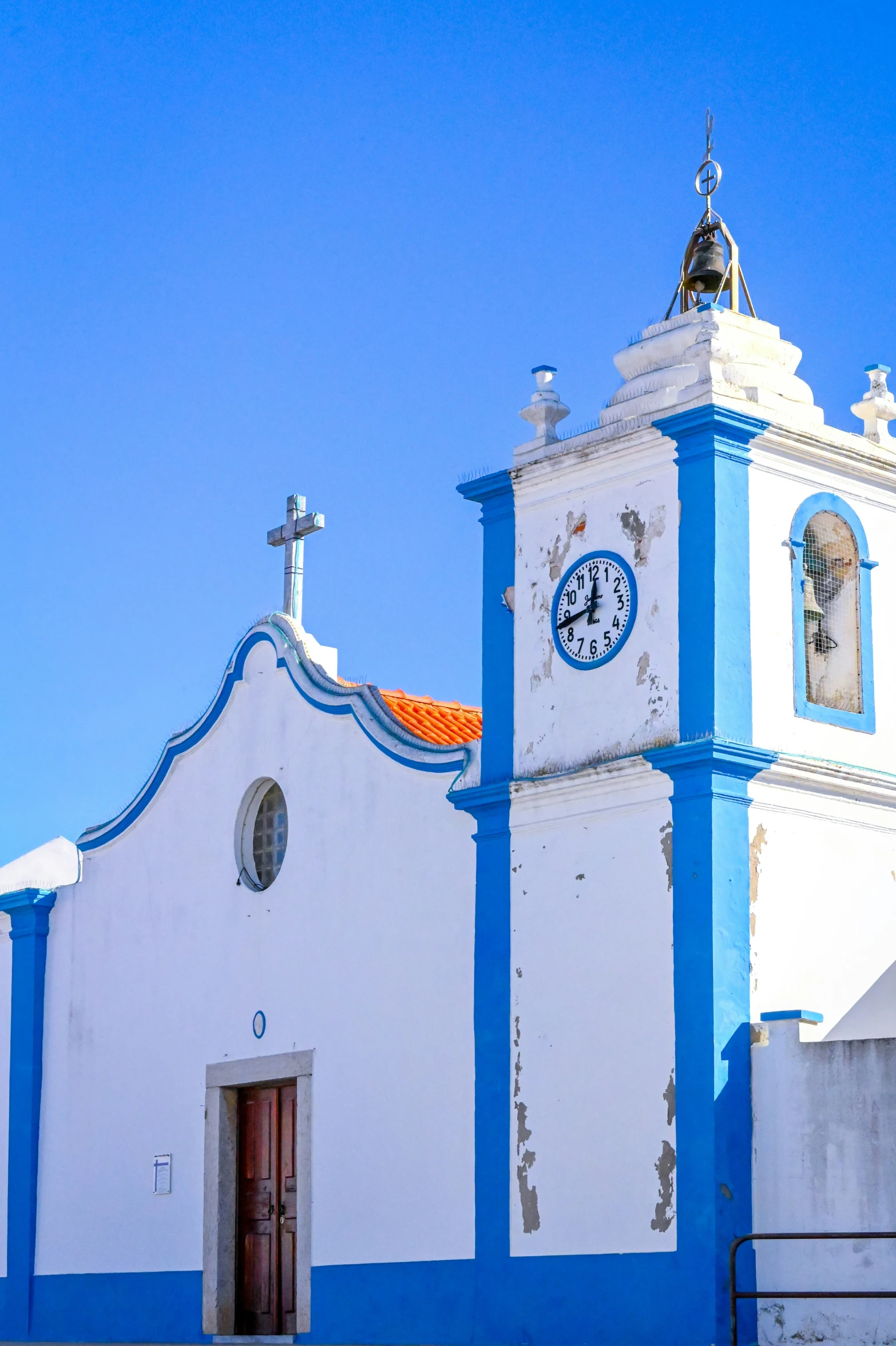 a blue and white church with an orange door