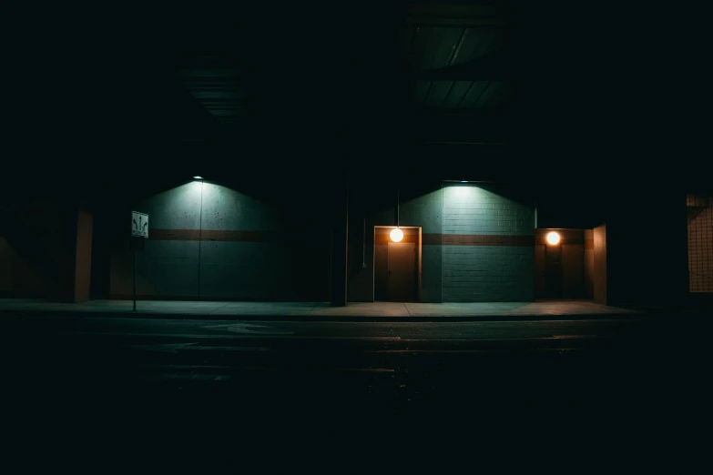 two garage doors with lights on at night