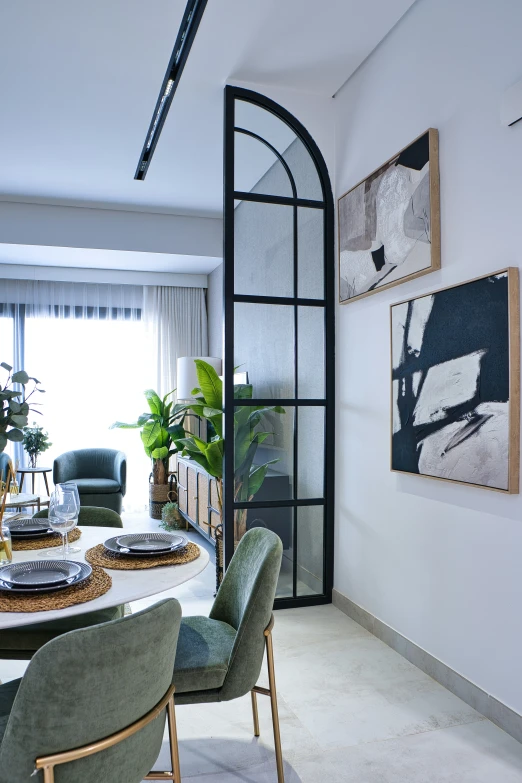 a dining room table with chairs, artwork and pictures on the wall