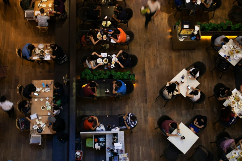 a restaurant with overhead view from above, people eating and talking