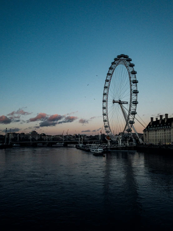 the ferris wheel stands out over the water