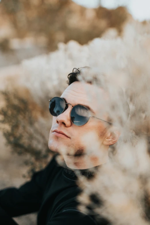 a man is wearing sunglasses and looking out to the desert