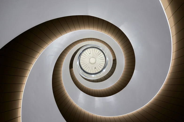 a spiral staircase with circular glass window at the end