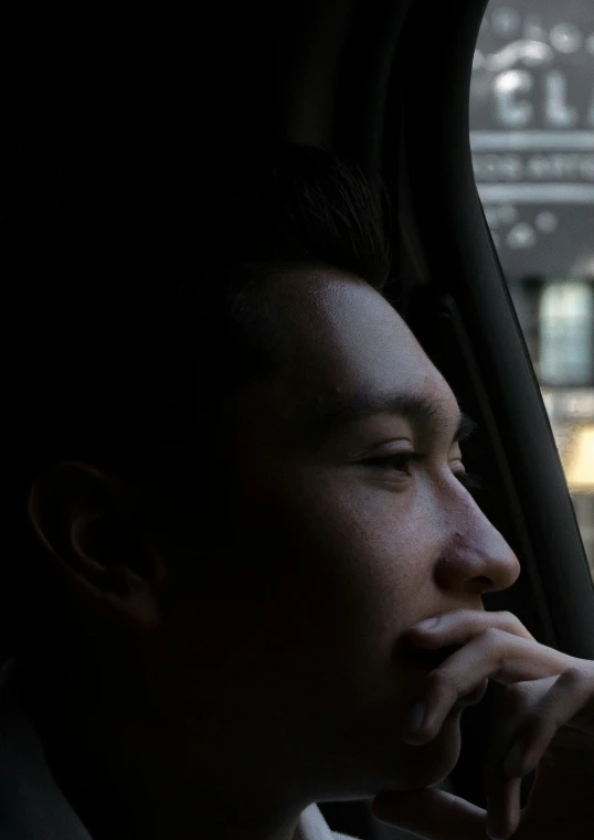 a man sitting in his car looking at a window