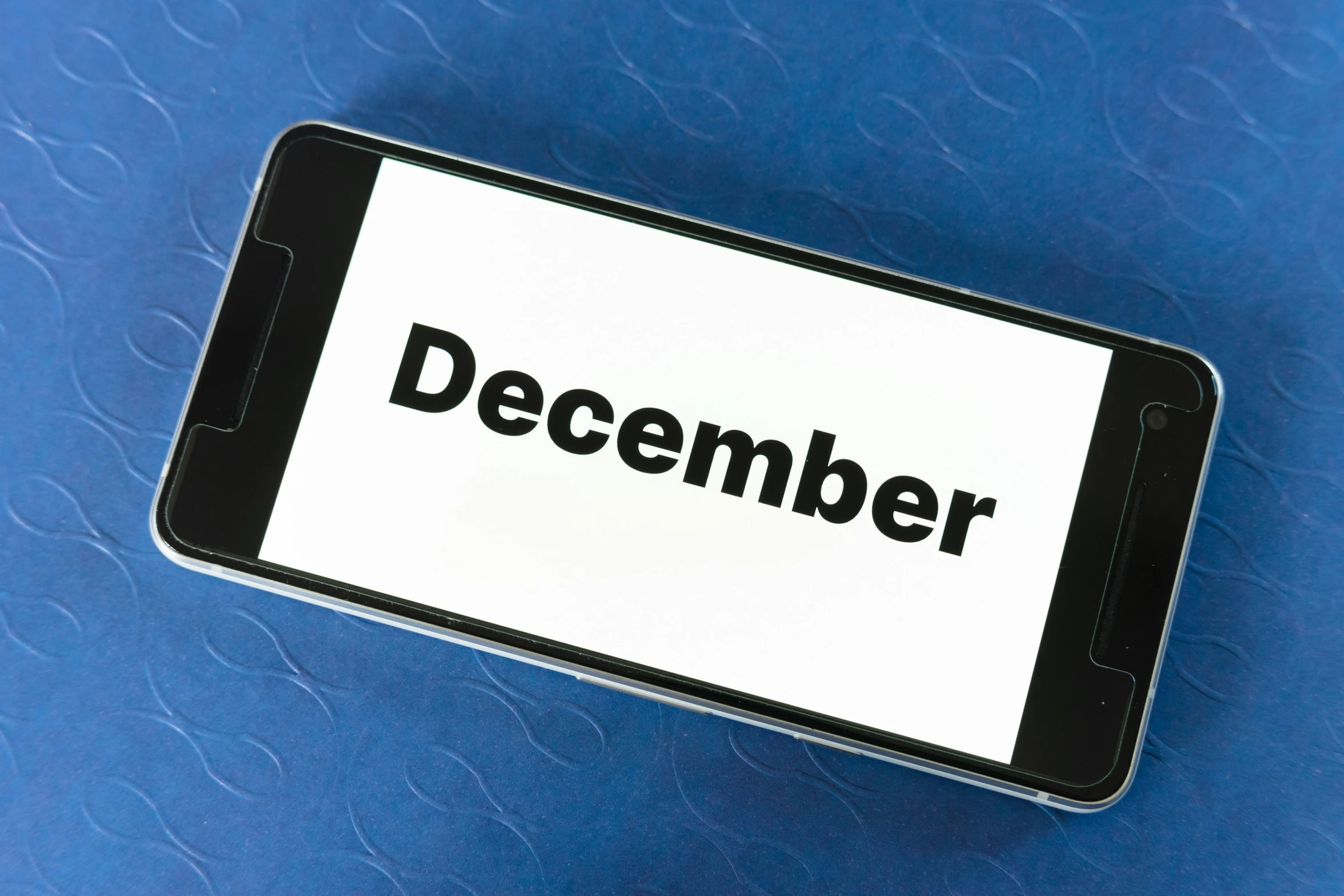 an iphone is shown with the word december written on the screen