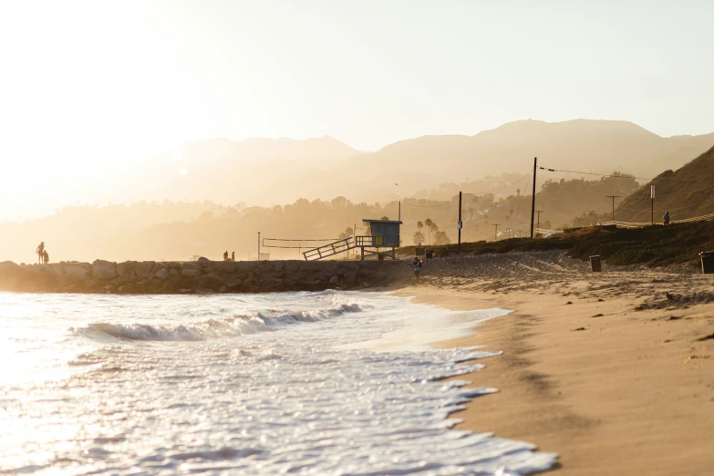 a beach with several people at it near the ocean