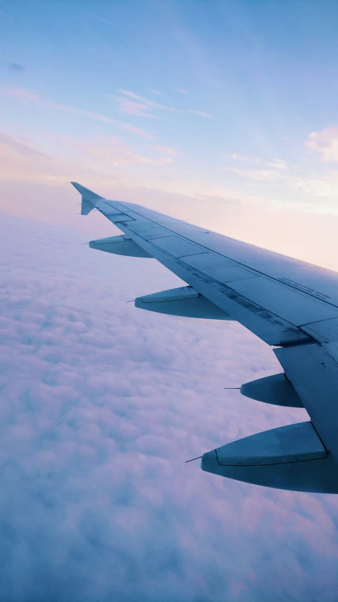 the wing of a airplane flying above a large body of water