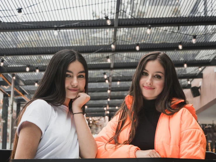 two girls in jackets are posing for a po