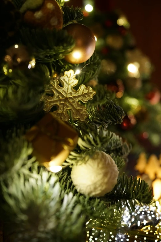 a green christmas tree decorated with gold ornaments